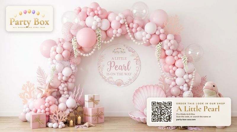 A Little Pearl baby shower balloon arch: pink, blush and pearl white balloons with pearl strands, seashells, coral and clear bubble balloons