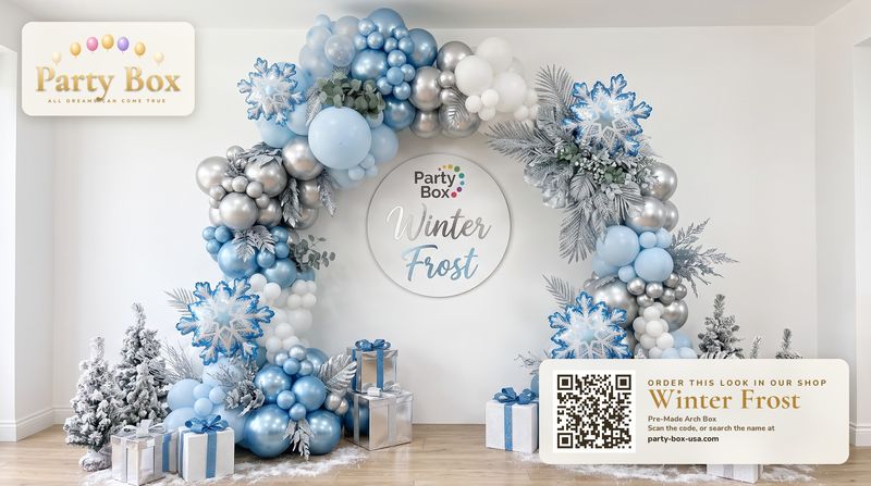 Winter Frost balloon arch: icy blue, silver chrome and white balloons with snowflake balloons, frosted greenery and flocked mini trees